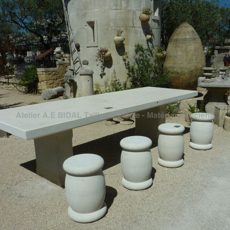 Des tabourets ronds et une longue table réalisée dans un matériau noble : la pierre naturelle