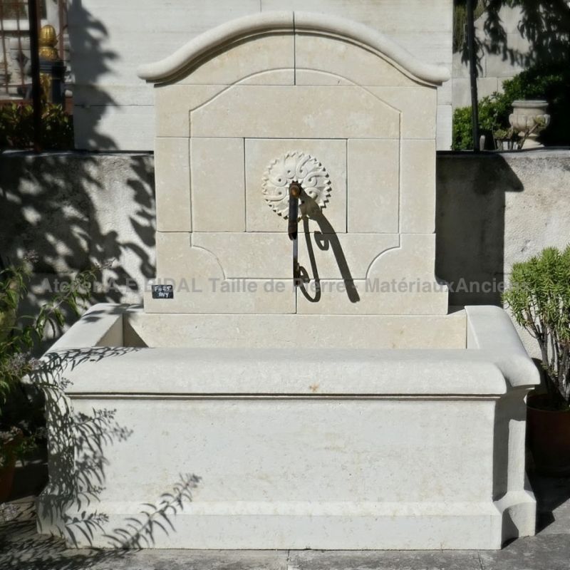 Une fontaine de jardin avec fronton et grand bassin de l'atelier Alain Bidal.