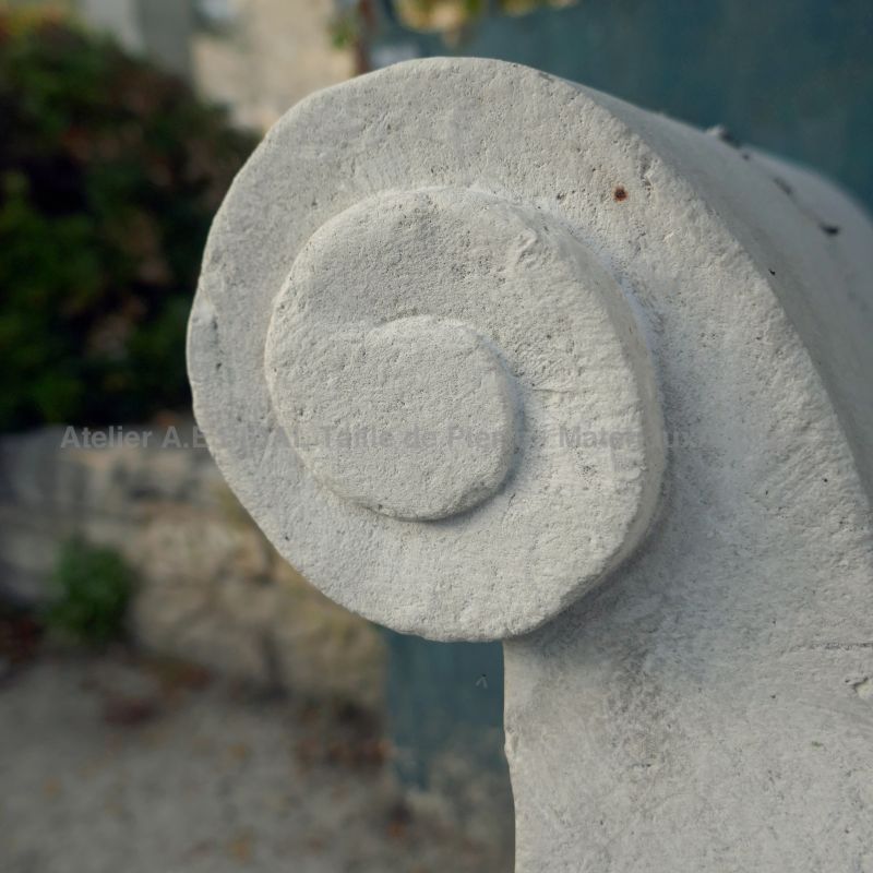 Détail de la volute sculptée à la main sur l'accoudoir de notre banc en pierre de taille