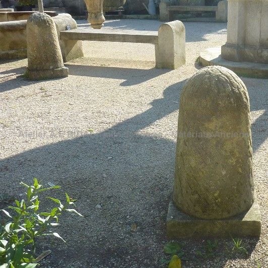 Borne en pierre taillée de style ancien à disposer dans un jardin.