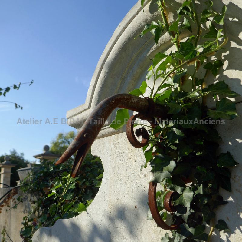Wrought iron water spout on our garden wall fountain in stone