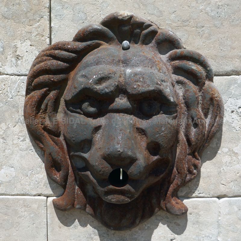 Detail of the cast iron lion's head, the water outlet on our large stone fountain