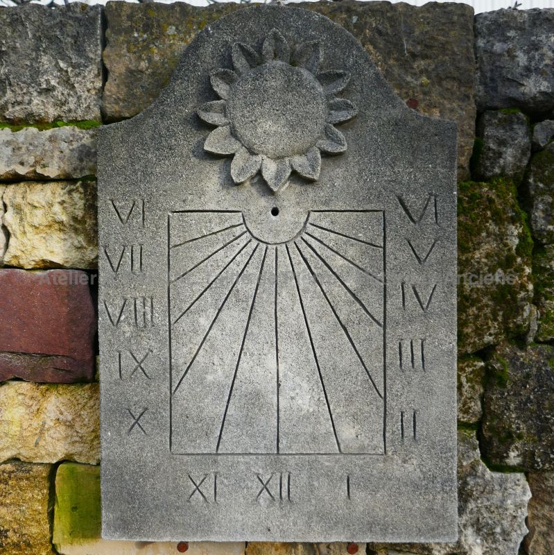Beau cadran solaire en pierre - sculpture en pierre par notre maitre artisan tailleur de pierre.