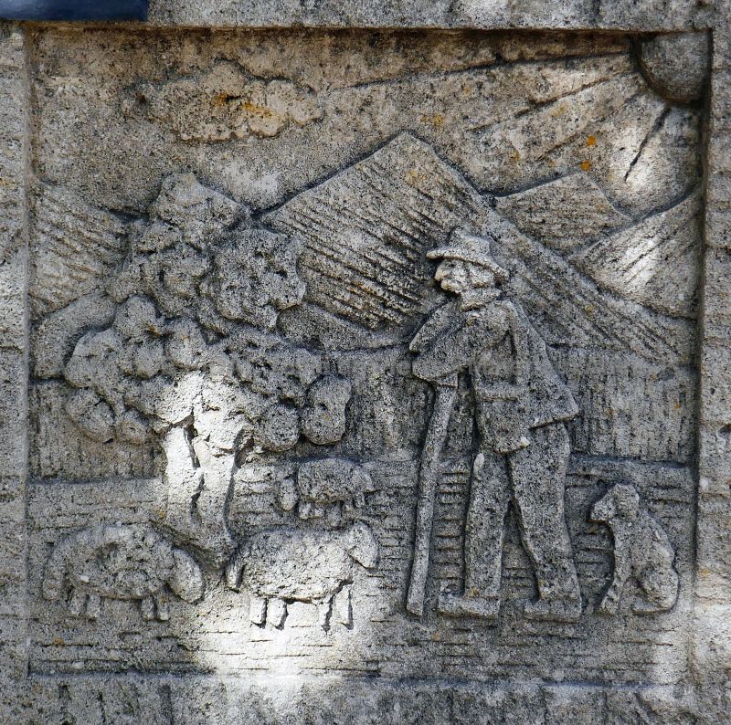 Fountain in natural stone with a pediment hand-sculpted with a rural scene