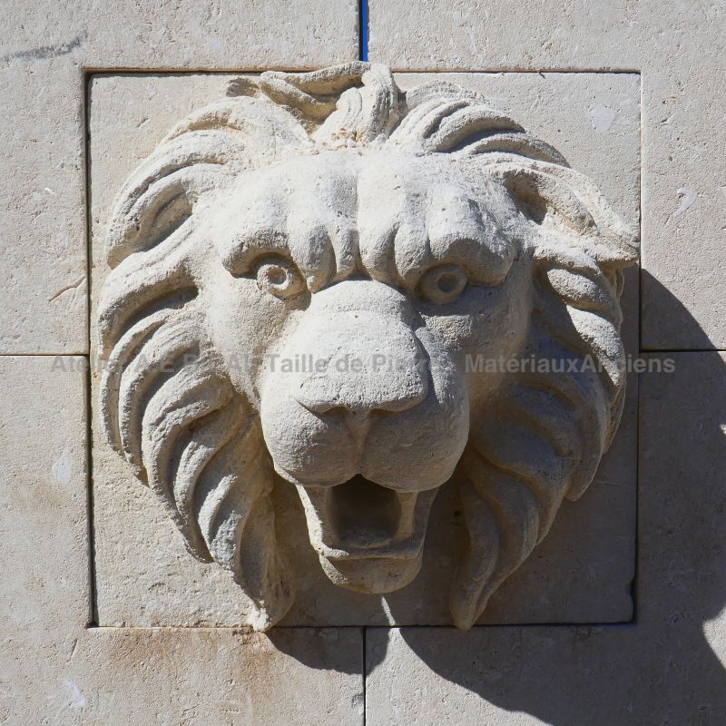 Stone sculpture of a lion's head on our rustic wall fountain
