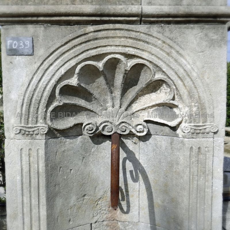Coquille sculptée à la main sur le fronton de notre fontaine murale en pierre.