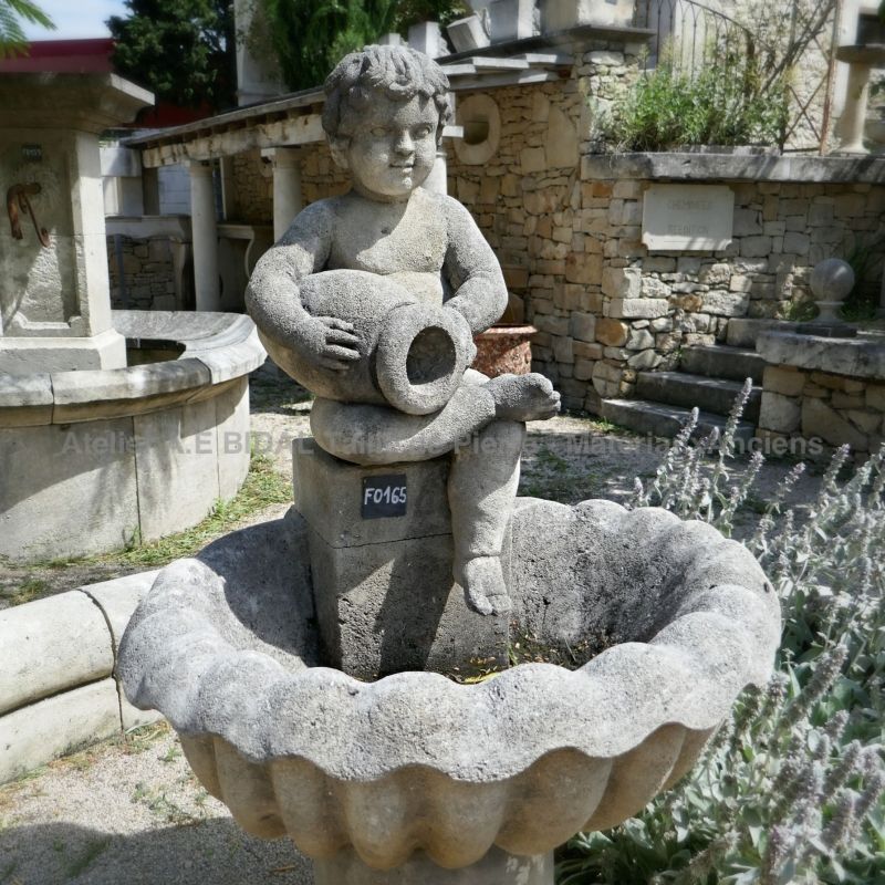 Angelot en pierre taillée sur fontaine centrale de jardin - Atelier Alain BIDAL (Provence)