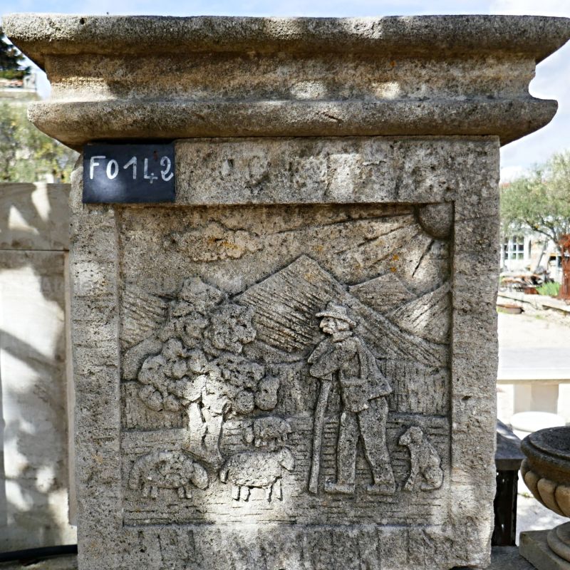 Fountain in natural stone with a pediment hand-sculpted with a rural scene