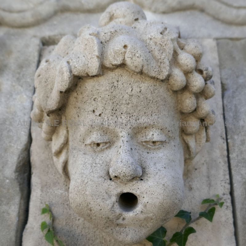 Detail of the hand carved stone water outlet on the pediment of our Provence stone garden fountain | Sale of fountains and basins in stone at Atelier Bidal.