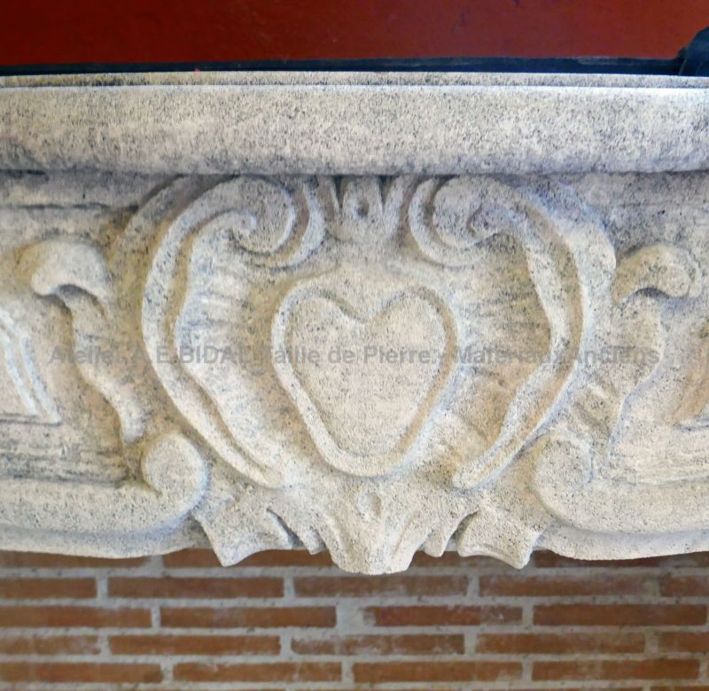 Détail de la coquille sculptée à la main sur la linteau de la cheminée Régence de l'Atelier Alain BIDAL.