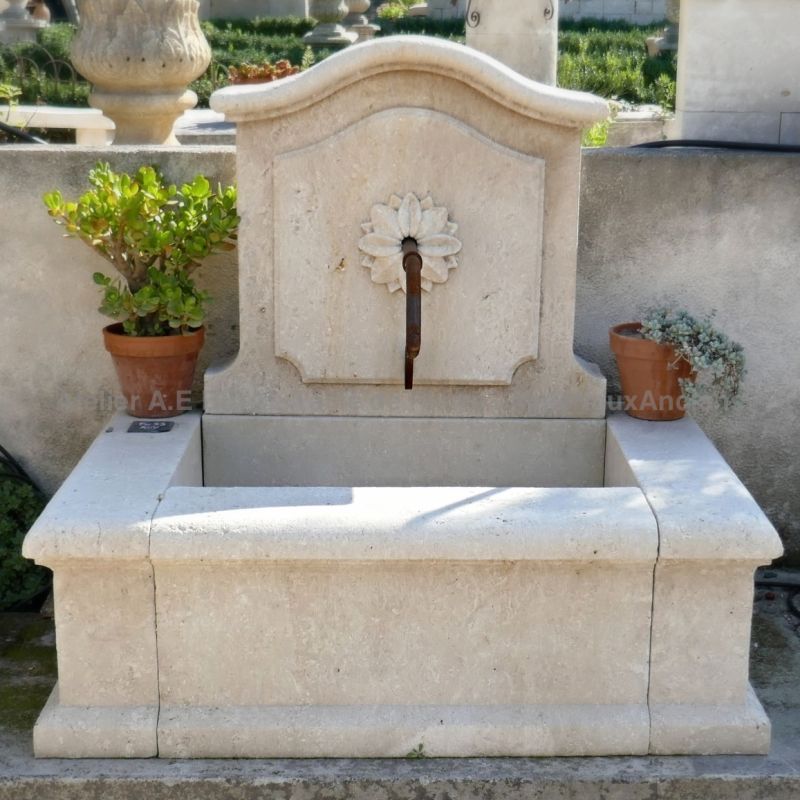 Fontaine murale de petite dimension en pierres naturelles par le tailleur de pierre Alain Bidal.