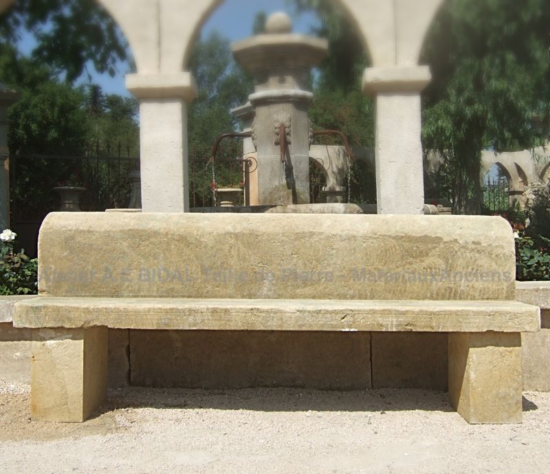 Grand banc en pierre de taille naturelle avec dossier des ateliers de fabrication artisanale de mobilier de jardin Alain Bidal.
