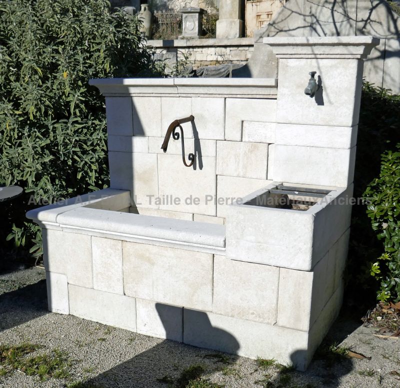 Fontaine provençale en pierre blanche signée Atelier Alain Bidal.