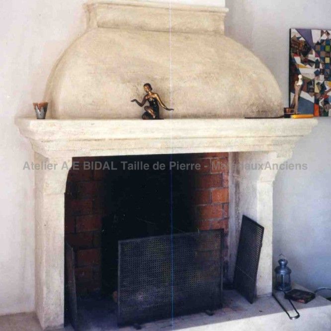 Cheminée provençale en pierre claire disposant d'une hotte - Atelier Alain BIDAL (Provence)