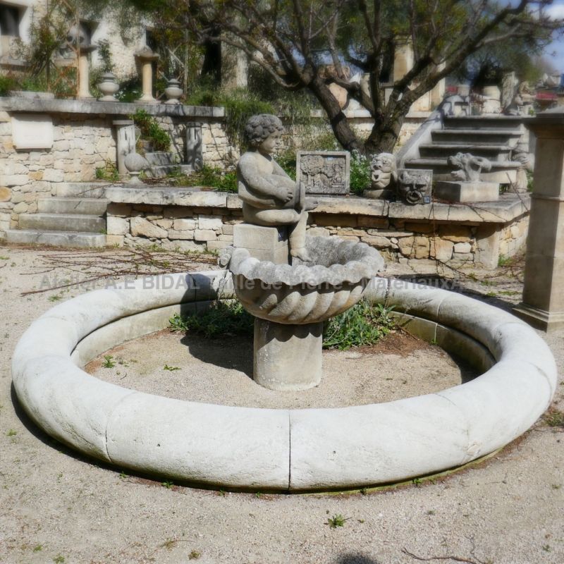 Large fontaine de jardin de forme ronde de l'atelier du tailleur de pierre Alain Bidal.
