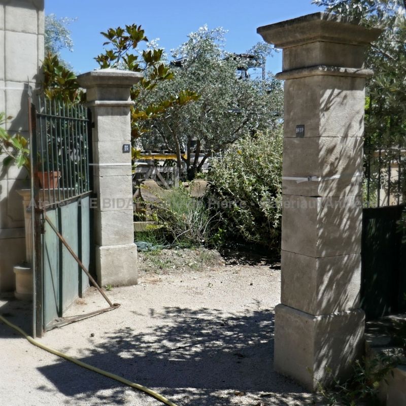 Gate pillars hand-carved in natural limestone and made to measure.