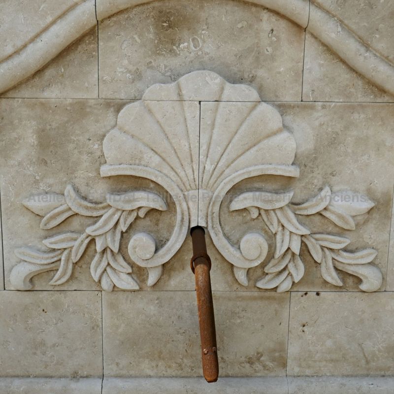 A fountain finely hand-sculpted with a floral motif on the pediment.