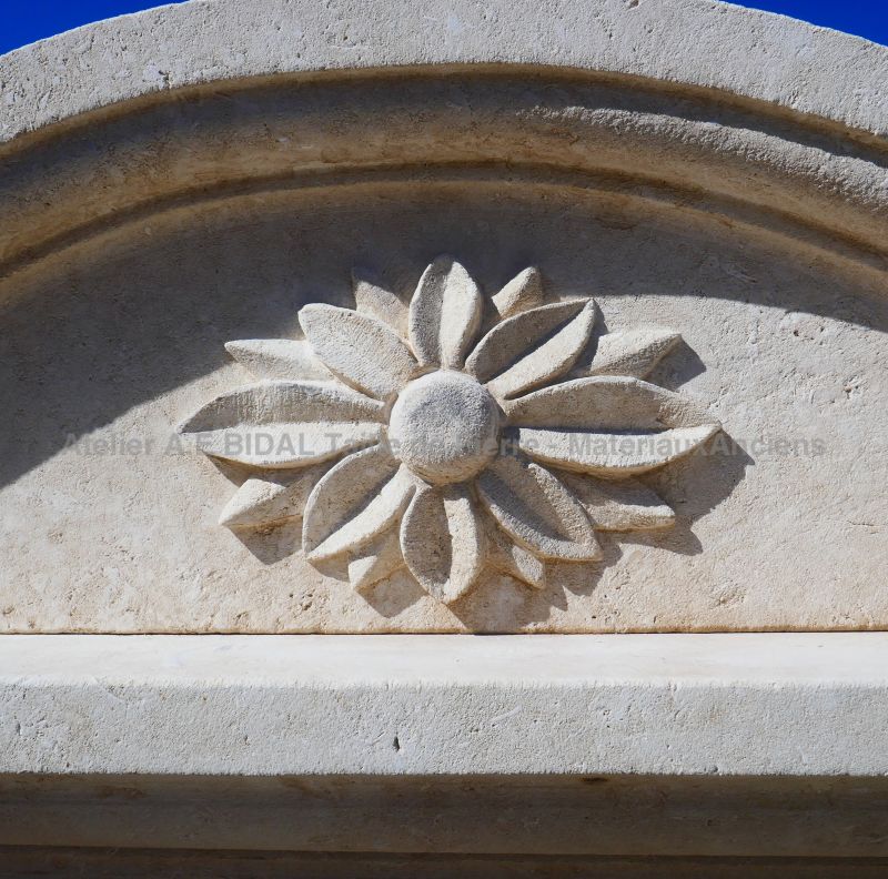 Hand carved flower on the molded cornice of our large stone fountain with lion's head